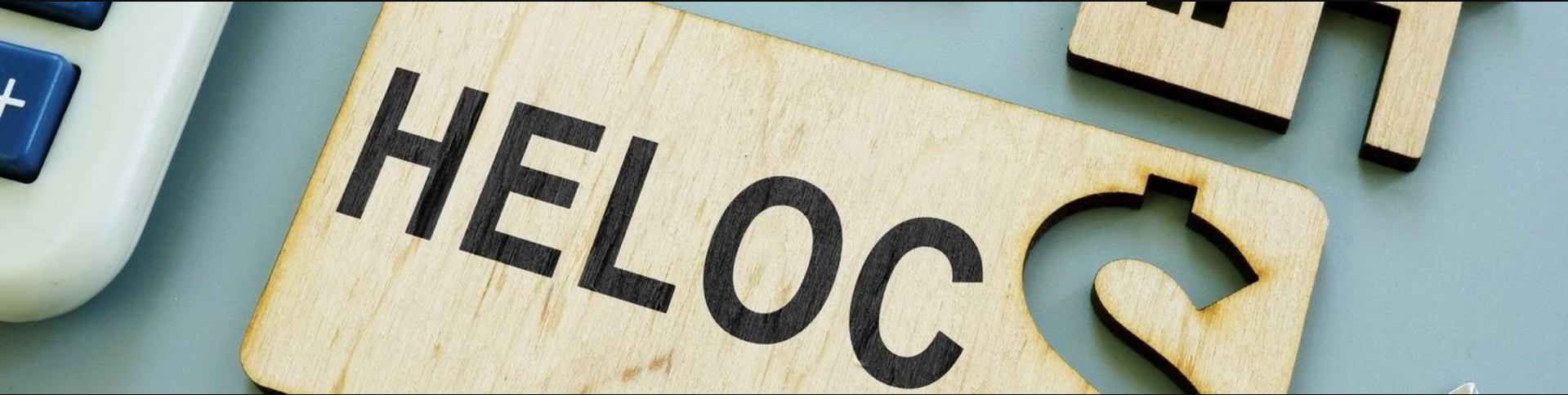 Piece of wood with "HELOC" written on it and dollar sign cutout