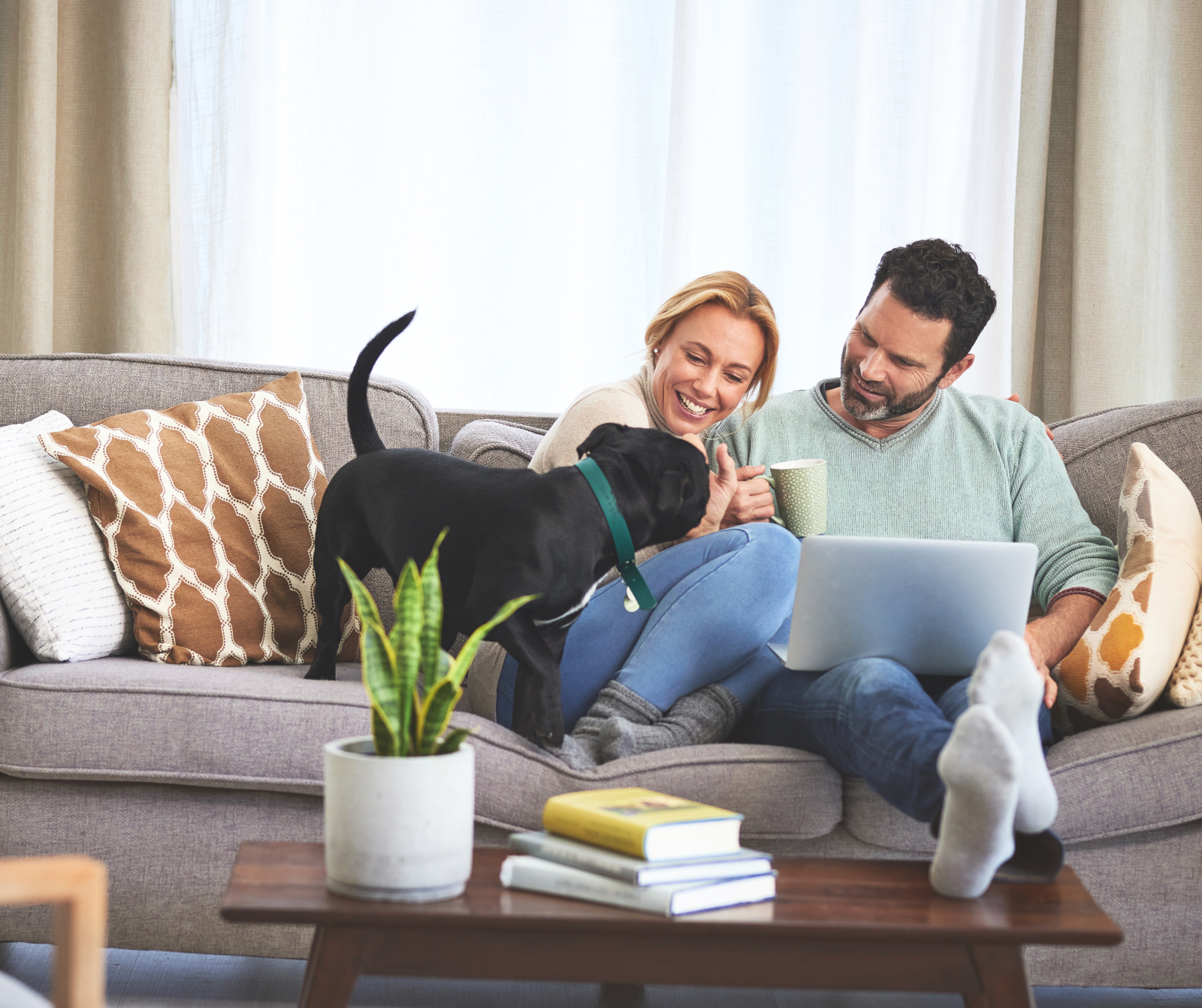 a couple and their puppy sitting on a couch