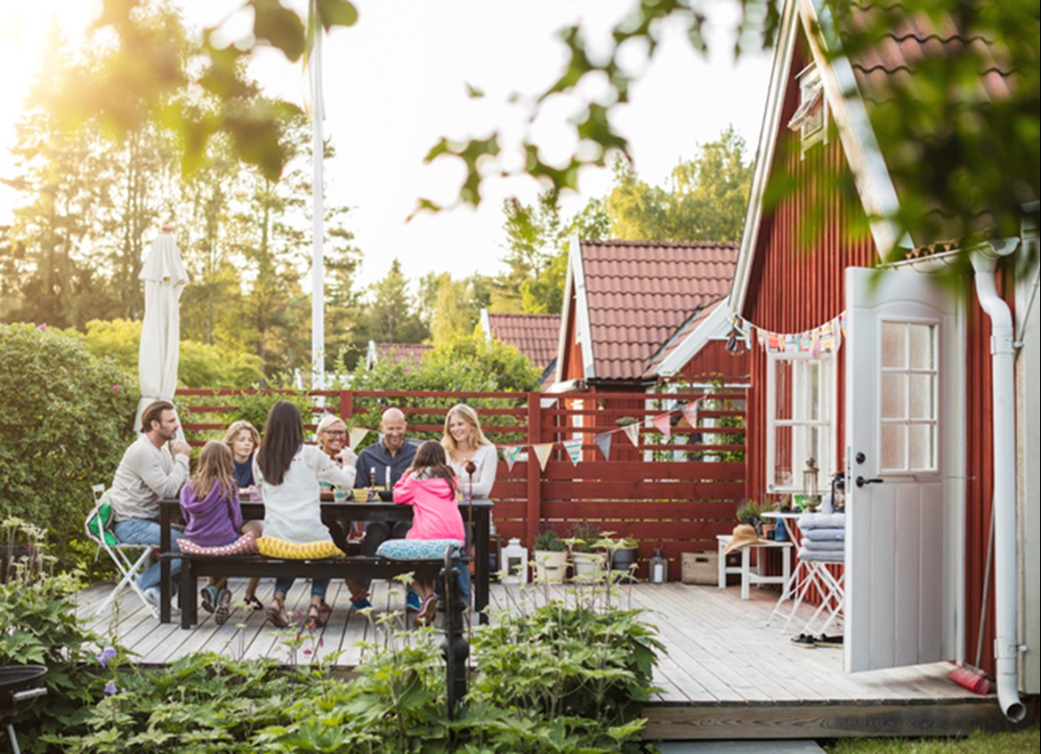 Extended family eating meal outside on back deck