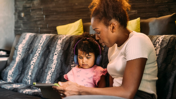 Mom showing young daughter iPad