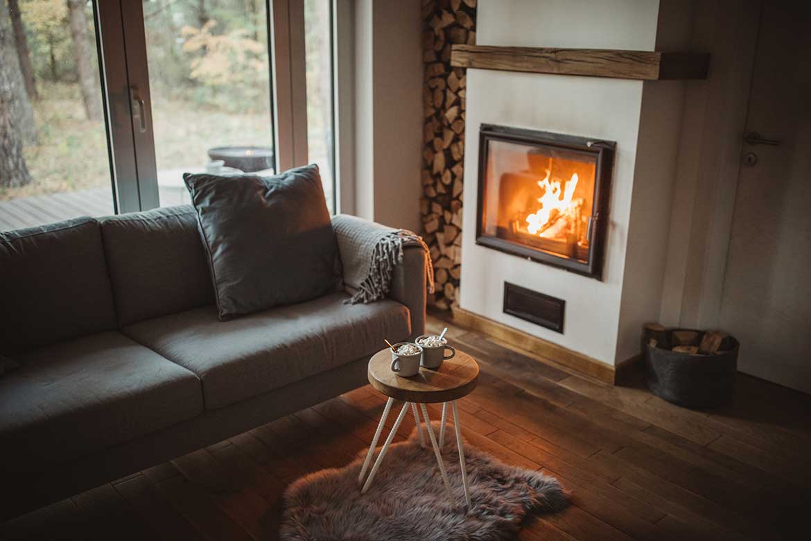 Living room with fireplace lit and mugs of hot chocolate on table