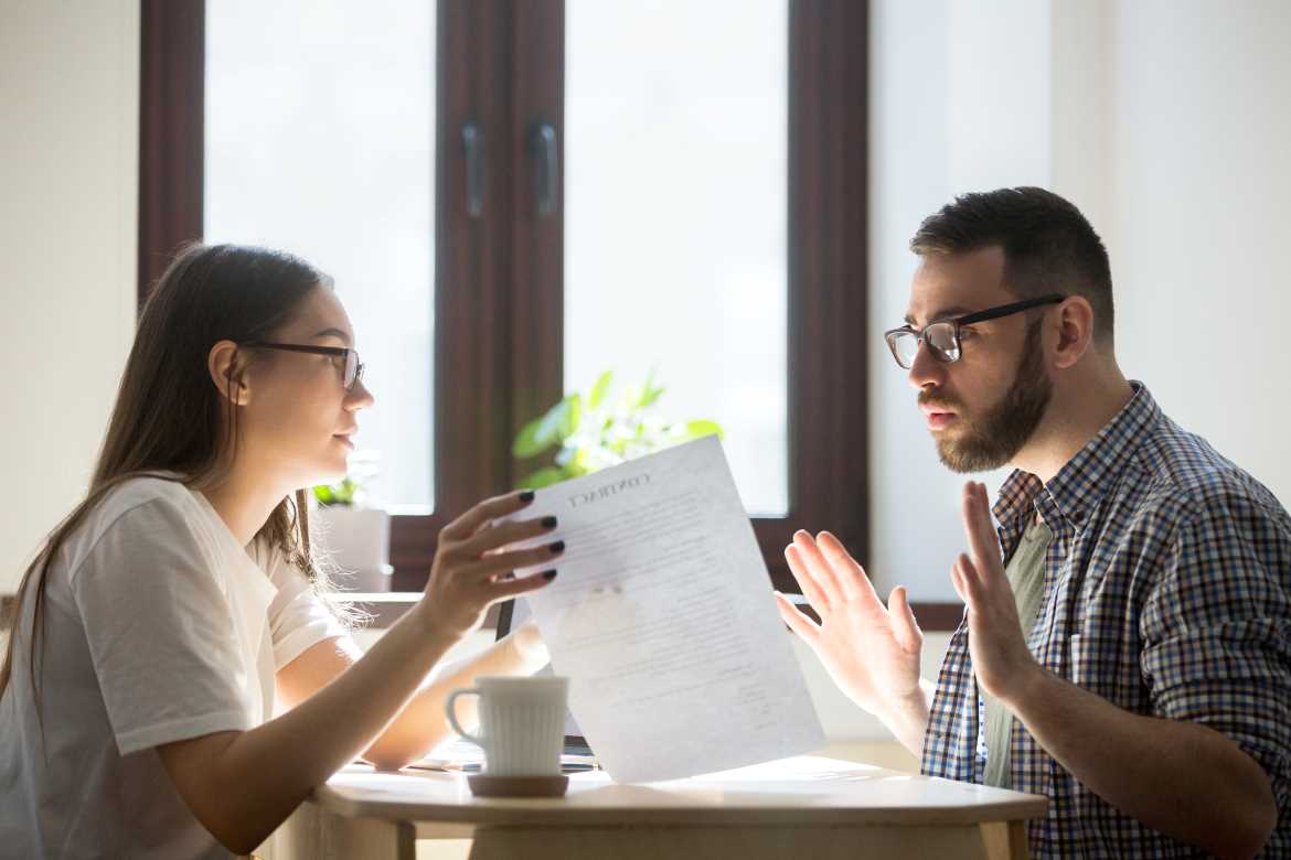 Couple sitting at table looking at documents with concern