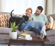 a couple and their puppy sitting on a couch