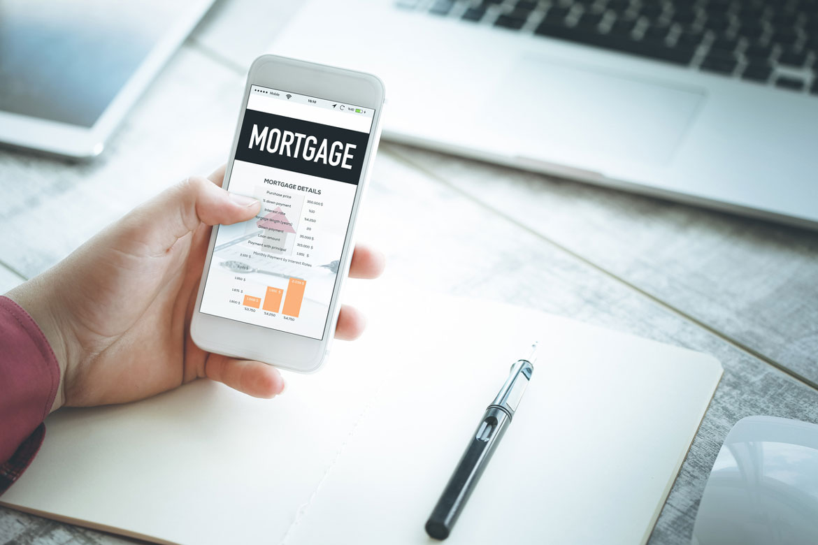 Hand holding phone with mortgage information on screen