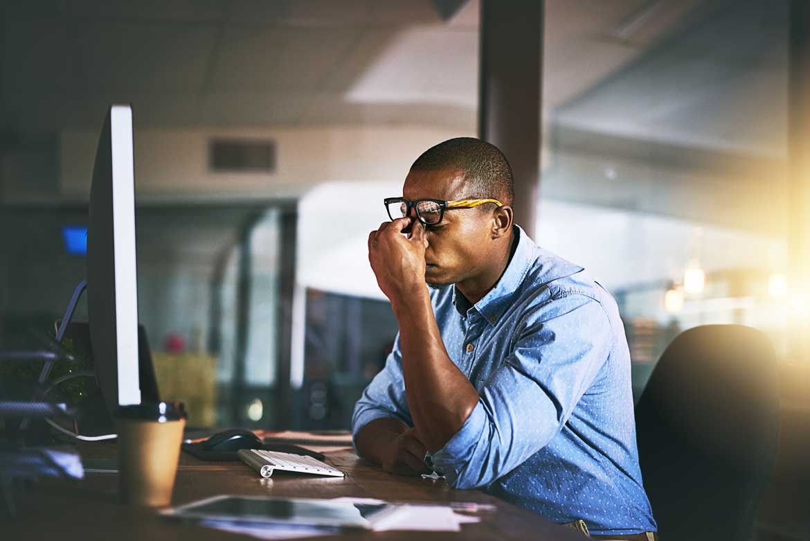 Distressed man looking at computer screen