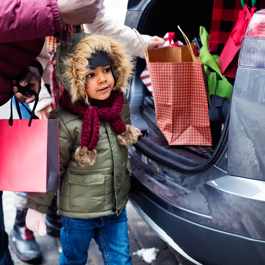 Child getting gifts out of a car